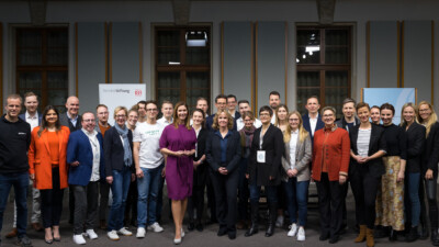 Gruppenfoto auf der Bühne des Finales der DFC 2022/23 mit allen Studierendenteams, der Jury, den Veranstalter*innen und Bundesumweltministerin Steffi Lemke