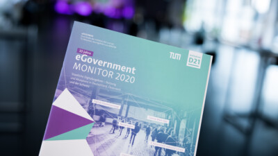 Eine Broschüre des eGovernment MONITOR 2020 wird beim GovTalk 2020 in die Kamera gehalten