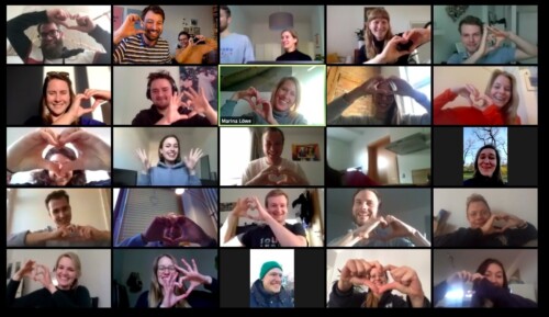 20 Personen in einer Videokonferenz formen mit ihren Händen Herzen