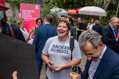 Dr. Julia Freudenberg, Leiterin der Hacker School und D21-Präsident Hannes Schwaderer herzlich lachend bei ihrer Unterhaltung.
