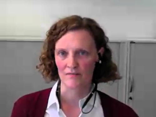 Screenshot von einer Videokonferenzsoftware. Eine Person spricht in die Kamera.