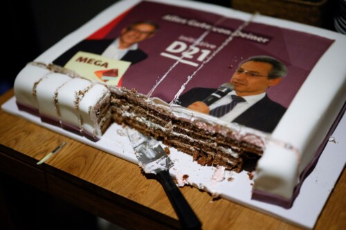 Eine rechteckige, angeschnittene Torte, auf die zwei Fotos von Hannes Schwaderer und der Text "Alles Gute von deiner Initiative D21" gedruckt ist.