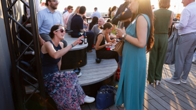 Viele Personen im Sonnenuntergang auf der Dachterrasse des rbb in Berlin