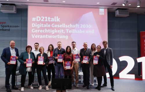 Die Partner*innen des D21-Digital-Index 2024/25 beim Gruppenfoto mit den Publikationen auf der Bühne