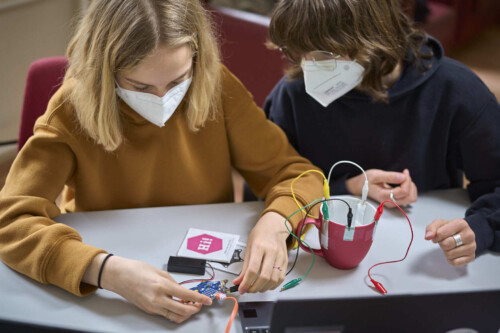 2 Schülerinnen bauen an einem Experiment mit Temperaturfühlern.