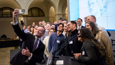 Minister Dr. Volker Wissing macht ein Gruppenselfie mit den Studierenden.